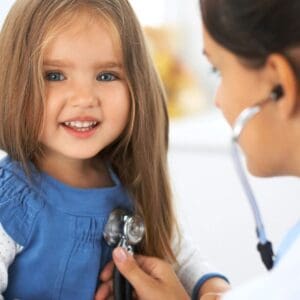 A little girl is being examined by a doctor.